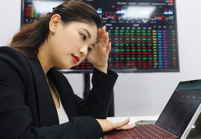 An investor watches market developments on her laptop screen. Photo courtesy of Vietnam News Agency.