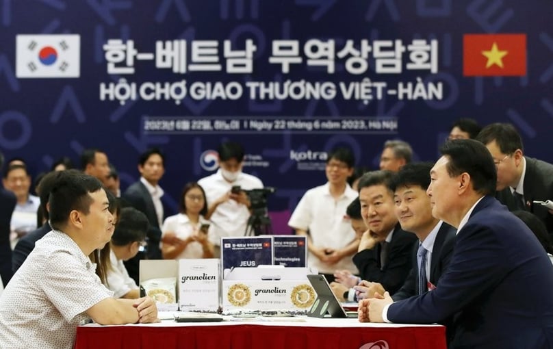 South Korean President Yoon Suk Yeol (R) talks with participants during a South Korea-Vietnam business partnership fair in Hanoi on June 22, 2023. Photo courtesy of Yonhap News Agency.