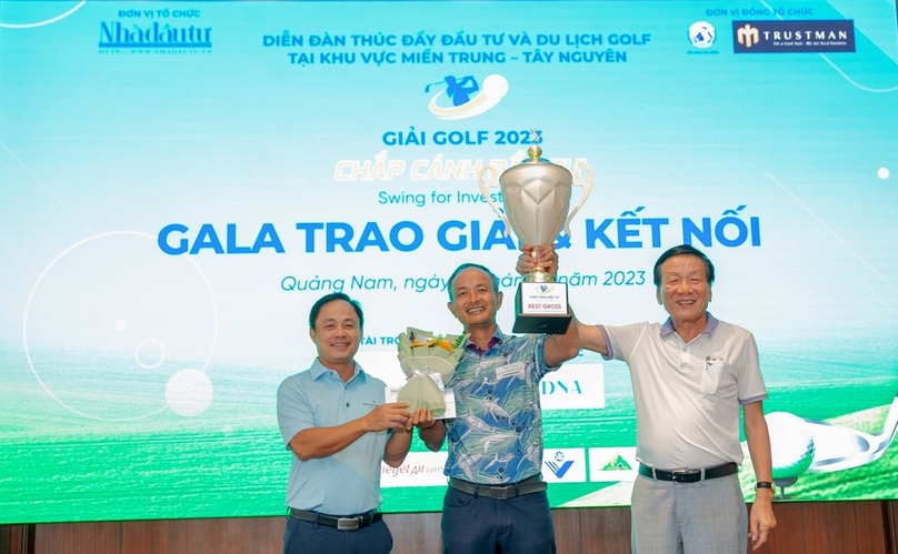 Nguyen Anh Tuan, Editor-in-chief of The Investor, and Nguyen Xuan Binh, vice director of Danang's Tourism Department, hands over the champions cup to golfer Trinh Chung. Photo by The Investor/Thanh Van.