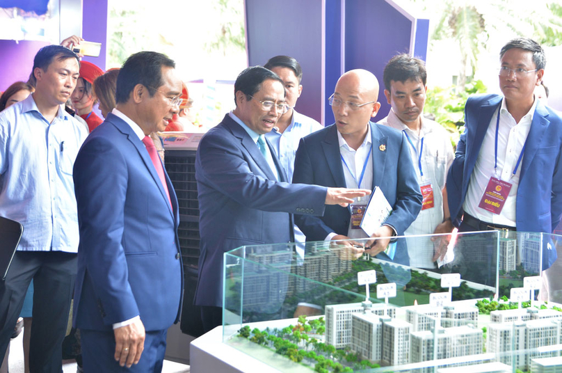 Prime Minister Pham Minh Chinh (front, 2nd from L) gestures as he inspects a housing development model in Long An, July 25, 2023. Photo courtesy of Long An newspaper.