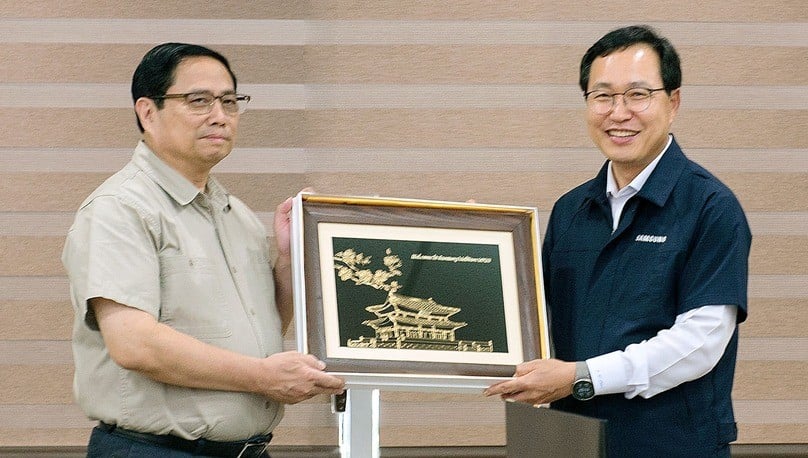 Prime Minister Pham Minh Chinh (L) gifts a souvenir to Samsung Vietnam CEO Choi Joo Ho at a meeting in Bac Ninh province, northern Vietnam, July 30, 2023. Photo courtesy of Bac Ninh newspaper.