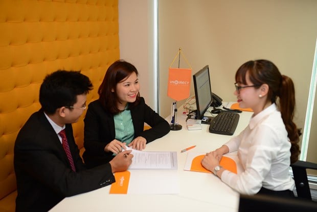 Staff of broker VNDirect guide a customer to open a securities account. Photo courtesy of VietnamPlus.