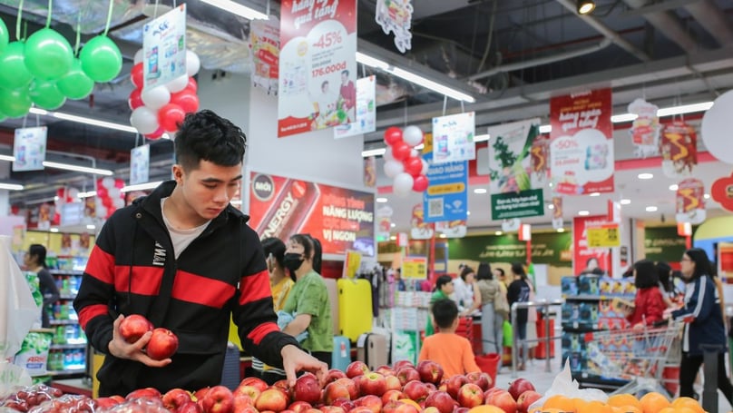 A customer picks apples in a supermarket. Photo by The Investor/Trong Hieu.