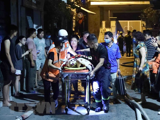 Rescue forces remove a victim from the fire at a mini apartment building on Khuong Ha street, Thanh Xuan district, Hanoi. Photo courtesy of Vietnam News Agency.