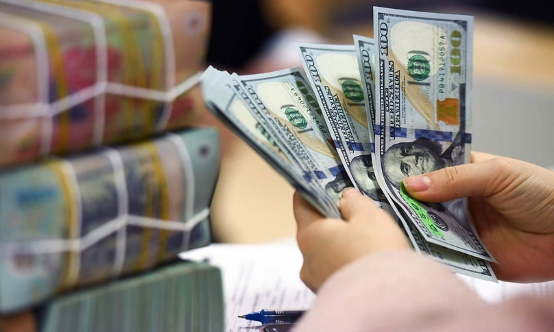 The U.S. dollar and the dong are seen during a transaction at a bank in Vietnam. Photo courtesy of VietNamNet.