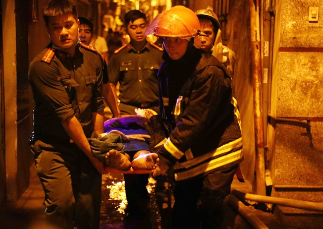 Fightfighters and rescue forces carry a victim from the fire at a mini apartment building on Khuong Ha street, Thanh Xuan district, Hanoi. Photo courtesy of Vietnam News Agency.