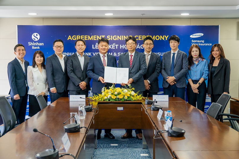 Kang GewWon, general director of Shinhan Bank Vietnam; Ye Young Hae, general director of Samsung Vina Insurance; and delegates at the agreement signing ceremony. Photo courtesy of the bank.