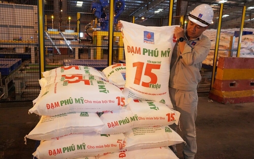 A PVFCCo worker with the package of the company's 15th-million ton of urea, October 10, 2023. Photo courtesy of the company.