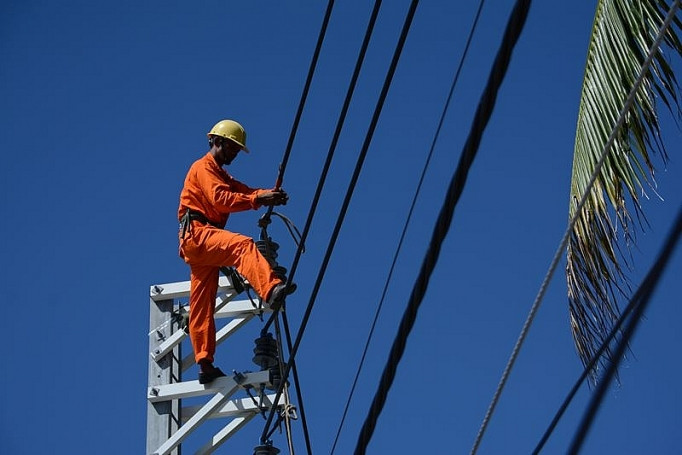A technician checks a transmission line. Photo courtesy of Cong Thuong (Industry & Trade) newspaper. 