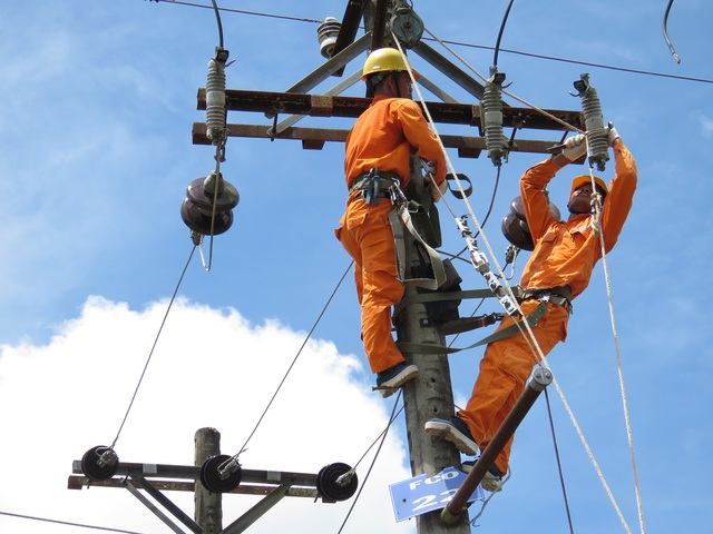 EVN workers repair a transmission line. Photo courtesy of the government's news portal. 