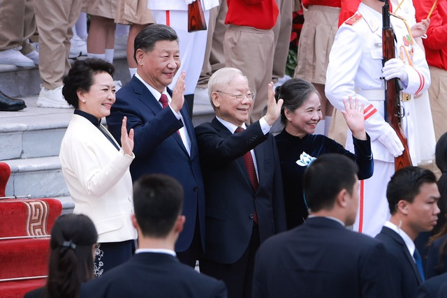 Vietnam's Party General Secretary Nguyen Phu Trong, China's Party General Secretary and President Xi Jinping, and their spouses wave hands at the welcome ceremony in Hanoi, December 12, 2023. Photo courtesy of the government's news portal.