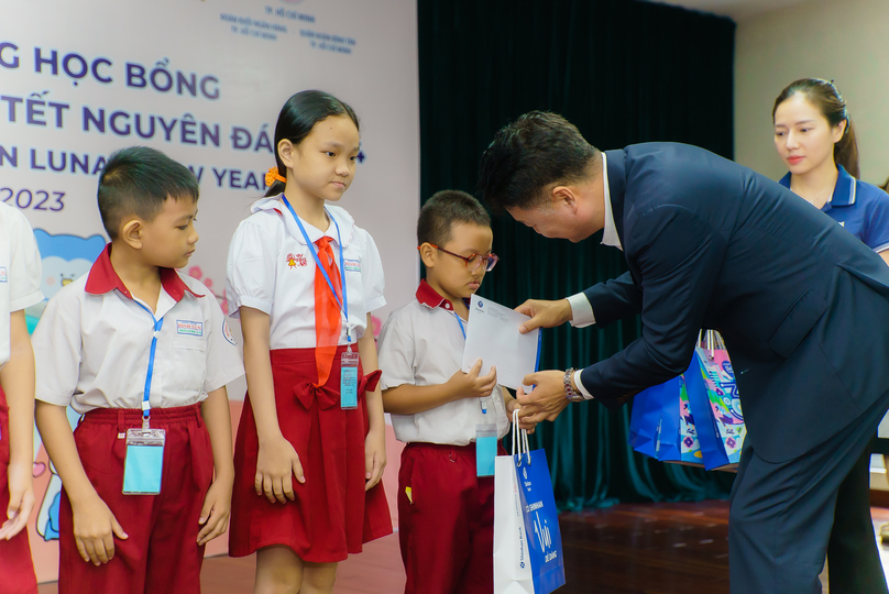 Kang GewWon (right), CEO and general director of Shinhan Bank Vietnam, delivers gifts to students. Photo courtesy of Shinhan Bank Vietnam.