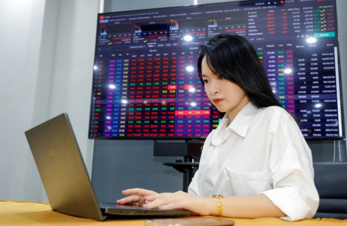 An investor watches market developments on her laptop. Photo courtesy of VietnamFinance.