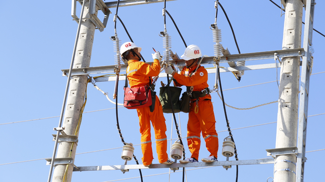 Workers of Vietnam Electricity (EVN) carry out repairs on a transmission line. Photo courtesy of the government's news portal.