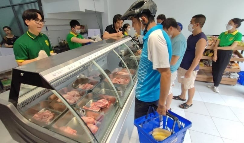 Customers shop for banana-fed pork at a Bapi store. Photo courtesy of Tuoi tre (Youth) newspaper.