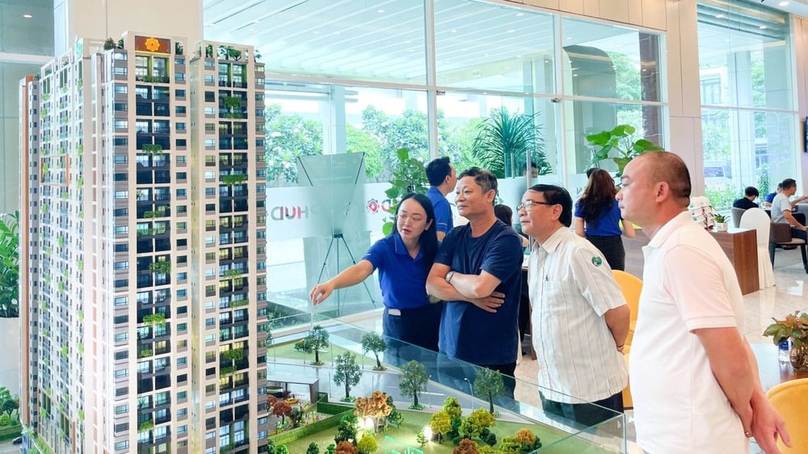 A sales woman introduces a real estate project to customers. Photo by The Investor/Vu Pham.