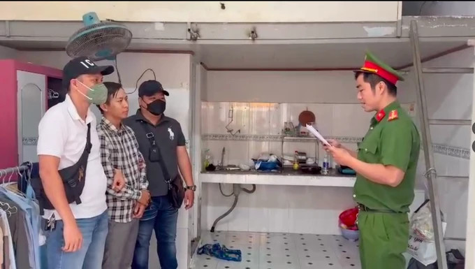 A policeman reads an order to arrest Le Xuan Dao, a contributor to a Hanoi-based newspaper. Photo courtesy of Sai Gon Giai Phong (Liberated Saigon) newspaper.