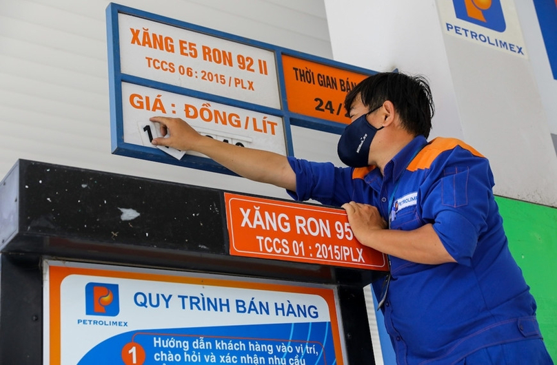 An employee changes gasoline prices on a gas station board. Photo courtesy of Vietnam government portal.