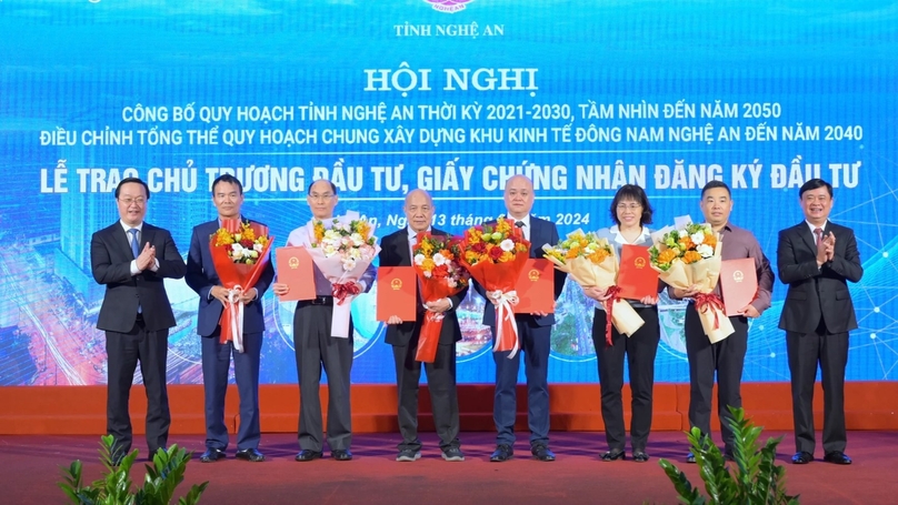 Nghe An Party Committee Secretary Thai Thanh Quy (right) and the province's Chairman Nguyen Duc Trung (left) pose with recipients of six investment certificates at a conference held in the central province, January 13, 2024. Photo courtesy of Nghe An newspaper.