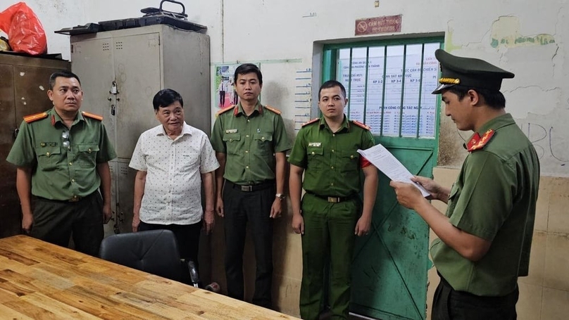 Nguyen Cong Khe (in white shirt), former editor-in-chief of Thanh Nien (Young People) newspaper, listens to his arrest warrant at a Ho Chi Minh City police station. Photo courtesy of HCMC police.