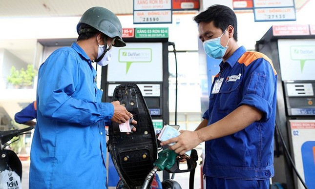 A gas station attendant pumps gasoline into a motorbike. Photo courtesy of Tien Phong (Vanguard) newspaper.