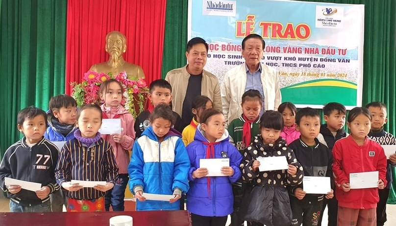 Nguyen Van Son (back, left), Ha Giang's Party chief and Chairman; Nguyen Anh Tuan (back, right), The Investor's editor in chief; and students of the Pho Cao primary and secondary school that receive scholarships in Ha Giang province, northern Vietnam, January 18, 2024. Photo by The Investor/Dinh Vu.