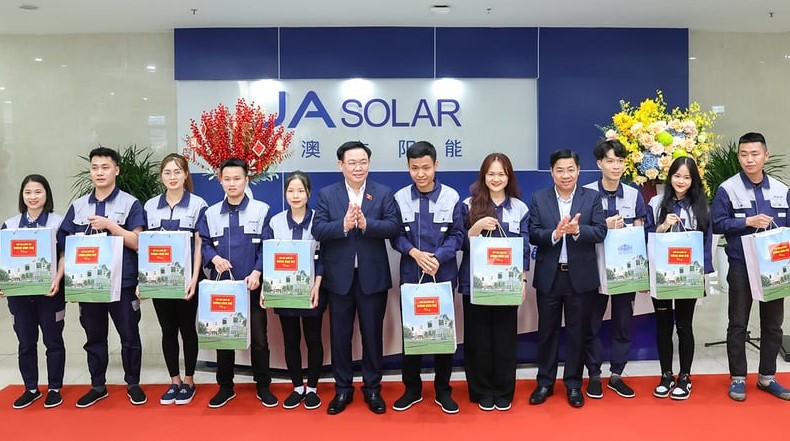 National Assembly Chairman Vuong Dinh Hue (center, left) and Duong Van Thai (center, right), chief of Bac Giang's Party Committee, grant gifts to JA Solar workers in the province, northern Vietnam, January 18, 2024. Photo courtesy of Bac Giang news portal.