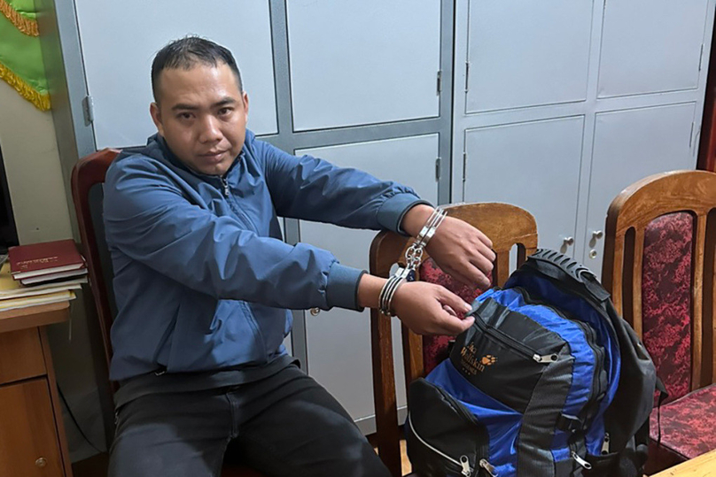 Suspect Nguyen Thanh Trung and the backpack containing the money he robbed at gunpoint from a VietinBank branch in Lam Dong province, Vietnam's Central Highlands. Photo courtesy of Lam Dong police.