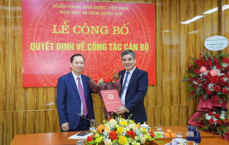 Permanent Deputy Governor of the State Bank of Vietnam Dao Minh Tu hands over the appointment decision to Nguyen Duc Cuong, new board chairman of the National Banknote Printing Factory. Photo courtesy of the SBV.