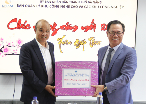 Phó Chủ tịch UBND tỉnh Lê Quang Nam (trái) trao quà Tết cho ông Vũ Quang Hùng, Giám đốc Ban Quản lý Khu công nghệ cao và các khu công nghiệp Đà Nẵng (DHPIZA), ngày 16/02/2034. Ảnh Báo Đà Nẵng. 