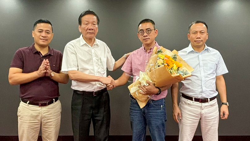 Nguyen Anh Tuan (second, left), editor-in-chief of the Nhadautu/Nhadautu.vn/The Intestor.vn publications, congratulates Nguyen Thai Son (second, right) on his new position as the head of the magazines’ Ho Chi Minh City southern office. Photo by The Investor/Kim Ngoc.