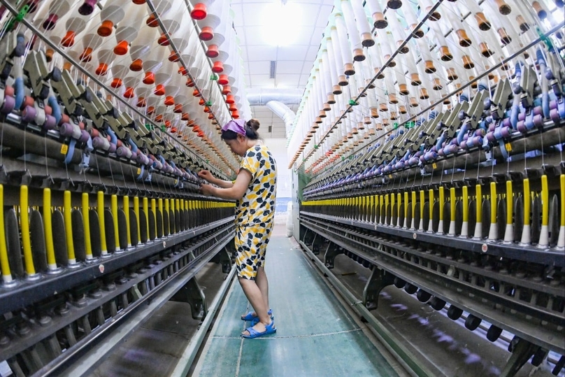 A worker checks a machine at the workshop of a textile enterprise in Qingzhou Economic Development Zone in east China’s Shandong province, July 27, 2022. Photo courtesy of SCMP/Getty Images.