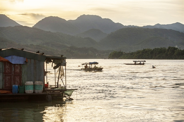 The picturesque mountains and tranquil rivers provide a beautiful scene, especially during the serene evenings on the Da River, where the fishing village rests beneath the Hoa Binh 3 bridge. Photo courtesy of Vietnam News Agency.