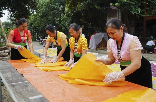  White Thai women make khau xen and chi chop cakes. Photo courtesy of Vietnam News Agency.