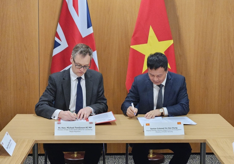 Minister for Countering Illegal Migration Michael Tomlinson (left) and Senior Colonel Vu Van Hung, deputy director general of the Department of Immigration under Vietnam’s Ministry of Public Security, sign an agreement in London, April 17, 2024. Photo courtesy of the UK Embassy in Hanoi.