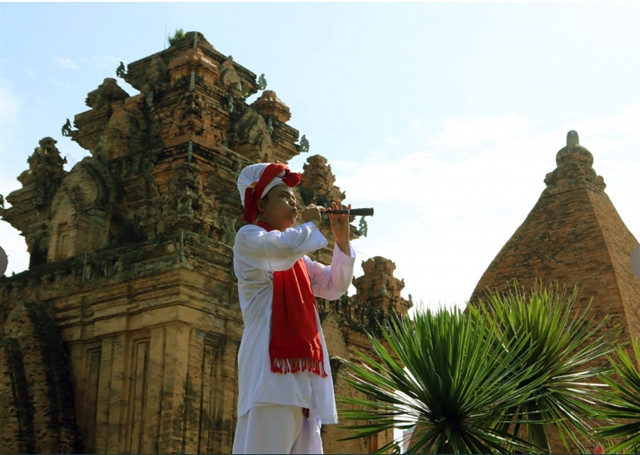  An ethnic Cham man performs traditional music by a Ponagar tower. Photo courtesy of vietnamnet.vn