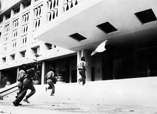 Soldier Bui Quang Than (holding the flag, front) followed by three soldiers of the Army Corps 2 – Huong Giang Corps enters and plants the flag on the roof of the Presidential Palace of the Republic of Vietnam at 11:30 am on April 30, 1975. Photo courtesy of Vietnam News Agency.