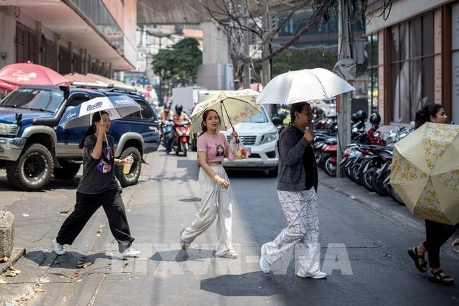  Hot weather hits people in Bangkok, Thailand. Photo courtesy of AFP/VNA.