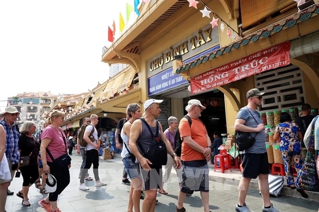 Foreigners visiting Binh Tay market, home to exquisite architecture in Ho Chi Minh City. Photo by Vietnam News.