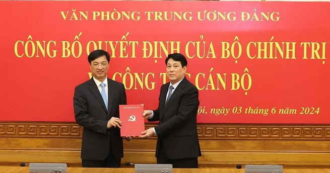 Luong Cuong (right), permanent member of the Party Central Committee’s Secretariat, hands over the Politburo’s decision on appointing Nguyen Duy Ngoc as Chief of the Party Central Committee Office. Photo courtesy of Vietnam News Agency.