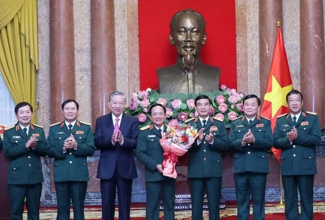 Trinh Van Quyet (fourth, right) is congratulated after receiving the decision on appointing him as head of the General Department of Politics. Photo courtesy of Vietnam News Agency.