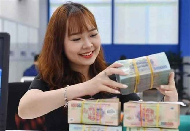 A bank teller counts money at a transaction office in Hà Nội. The VAMC must plan feasible measures to handle bad debts and its collateral before the purchase. Photo cafef.vn