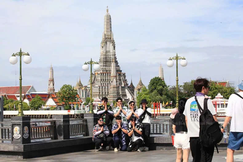 Tourists pose for pictures at the Tha Tien pier by Chao Phraya River opposite the Temple of Dawn (Wat Arun) in Bangkok, June 2024. Photo courtesy of Bangkokpost.