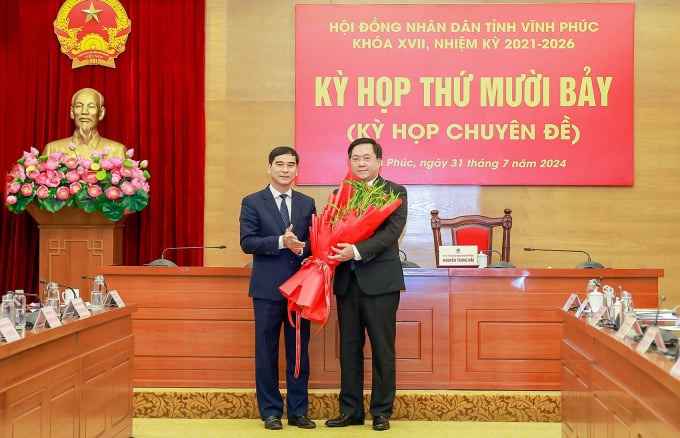 Newly-elected Vinh Phuc Chairman Tran Duy Dong (right) receives congratulatory flowers from provincial Party chief Duong Van An, July 31, 2024. Photo courtesy of Vinh Phuc newspaper.