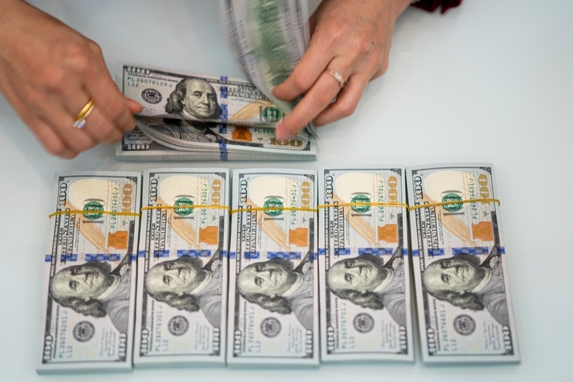 A clerk counts USD banknotes at an HDBank transaction office. Photo courtesy of Zing News.