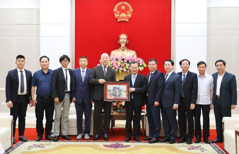 Quang Ninh province’s Chairman Cao Tuong Huy (sixth from right) presents a painting depicting Ha Long Bay to Azuma Yoshiro, president of the TNG association. Photo courtesy of Quang Ninh newspaper.