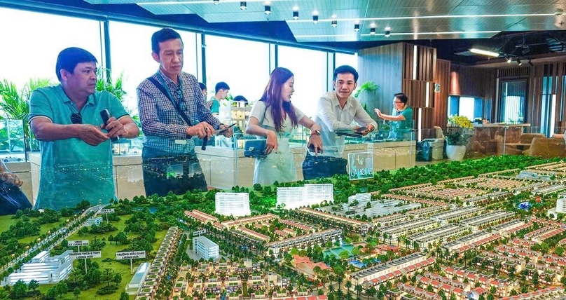 Potential clients study a large model of the LA Home project at the Hallmark building in Ho Chi Minh City. Photo by The Investor/Vu Pham.