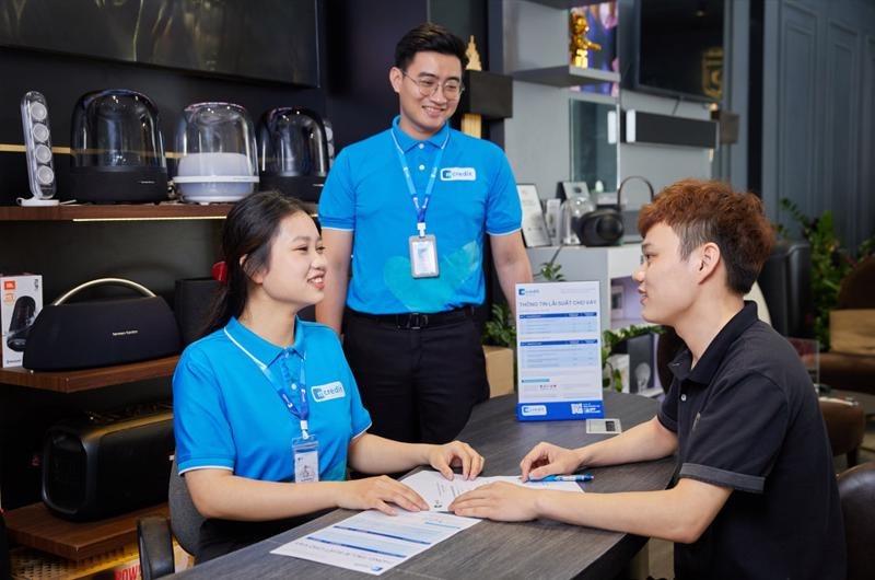  Mcredit clerks (in blue uniform) talk to a client. Photo courtesy of the company.