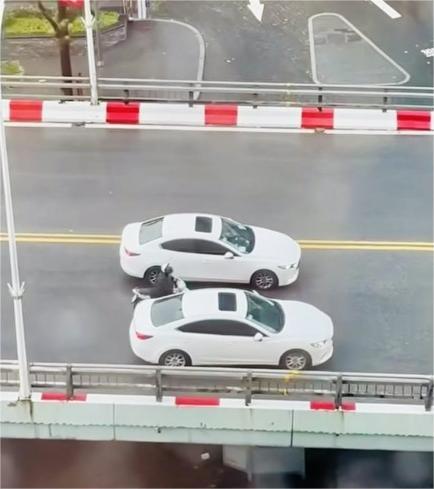 Two white cars coordinating to escort a motorbike across overpass in Lieu Giai ward, Hanoi, September 7, 2024. Photo taken from social media.