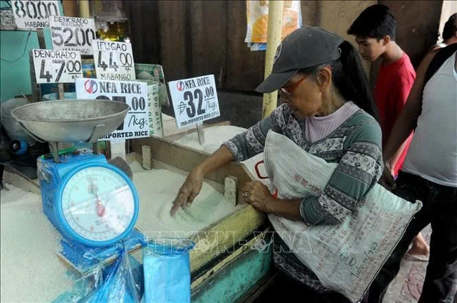  Customers buy rice at a market in Manila, the Philippines. Photo courtesy of AFP/VNA.